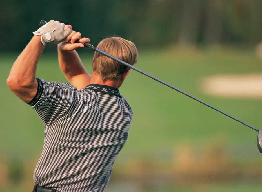 Man exercising shoulder by swinging a golf club