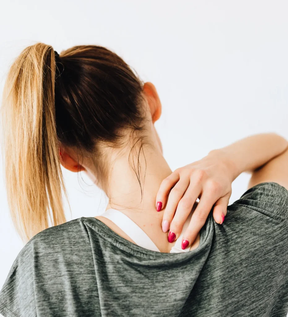 Woman putting hand on upper spine/shoulder region