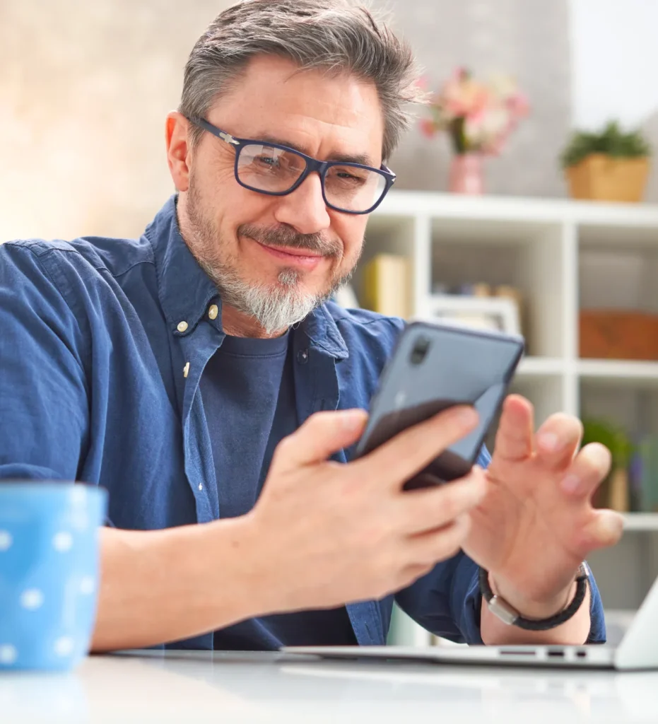 Man on smart phone smiling while scrolling